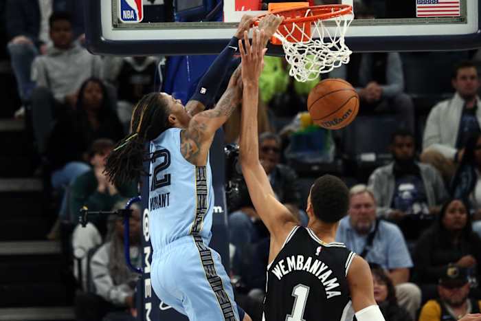 Jan 2, 2024; Memphis, Tennessee, USA; Memphis Grizzlies guard Ja Morant (12) dunks over San Antonio Spurs center Victor Wembanyama (1) during the second half at FedExForum.